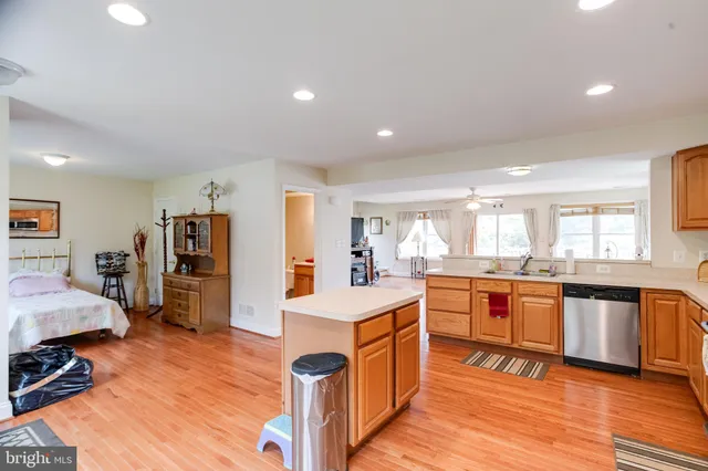 a living room with stainless steel appliances granite countertop furniture and a wooden floor