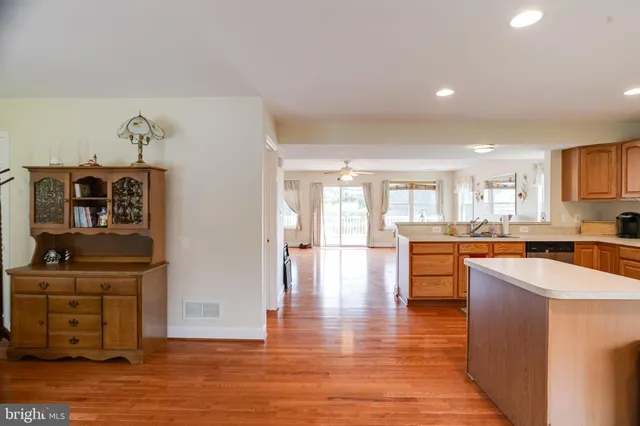 a living room with furniture dining table wooden floor and a window