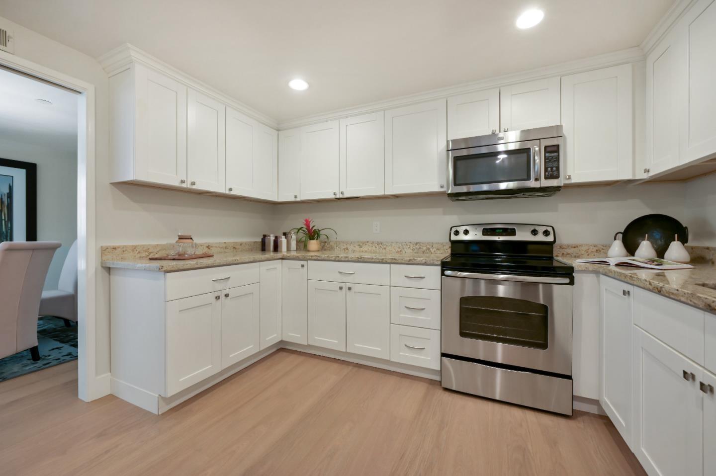 110 Park Road, Unit 502 Burlingame, CA 94010 - Photo 11 of 43 a kitchen with stainless steel appliances granite countertop a stove a sink and white cabinets