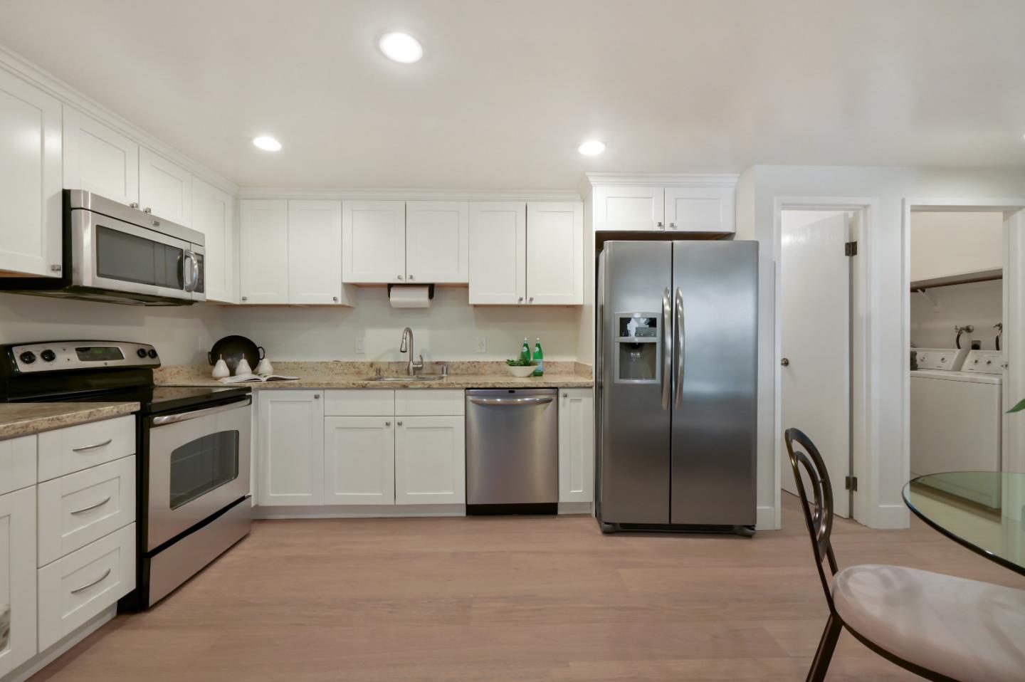 110 Park Road, Unit 502 Burlingame, CA 94010 - Photo 12 of 43 a kitchen with stainless steel appliances granite countertop a stove a sink and a refrigerator