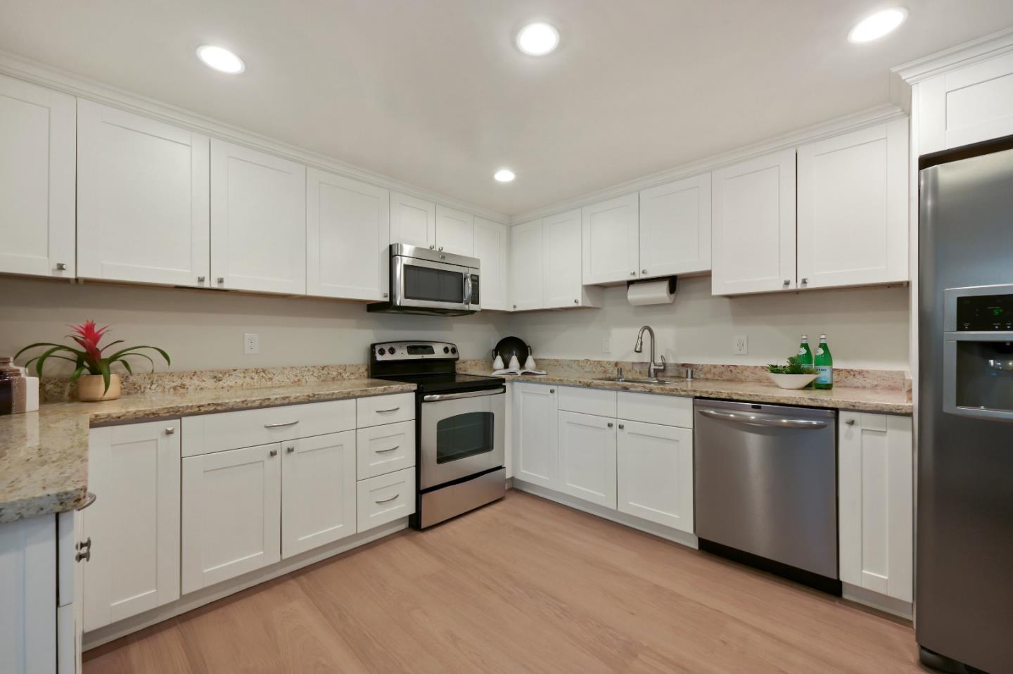110 Park Road, Unit 502 Burlingame, CA 94010 - Photo 10 of 43 a kitchen with granite countertop white cabinets and white appliances