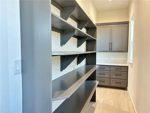 a kitchen with white cabinets and window