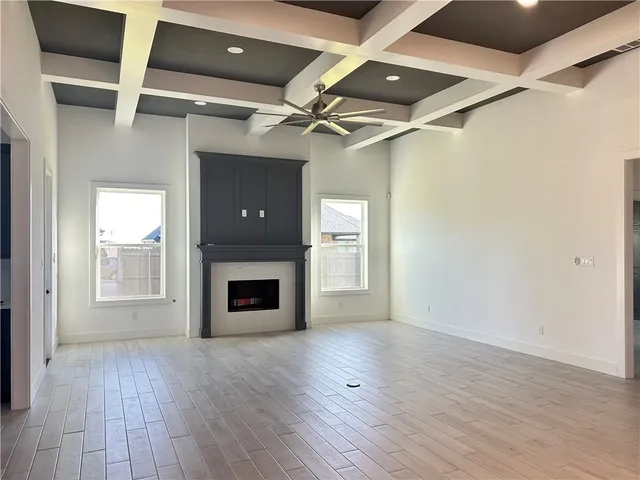 a view of an empty room with a fireplace and a window