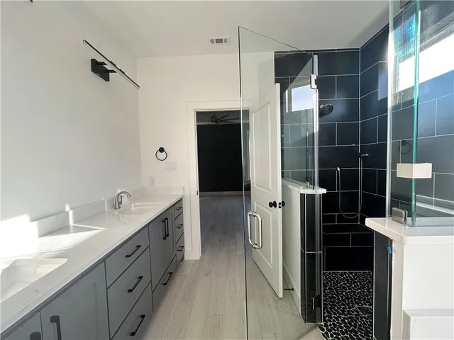 a bathroom with a double vanity sink a and a shower