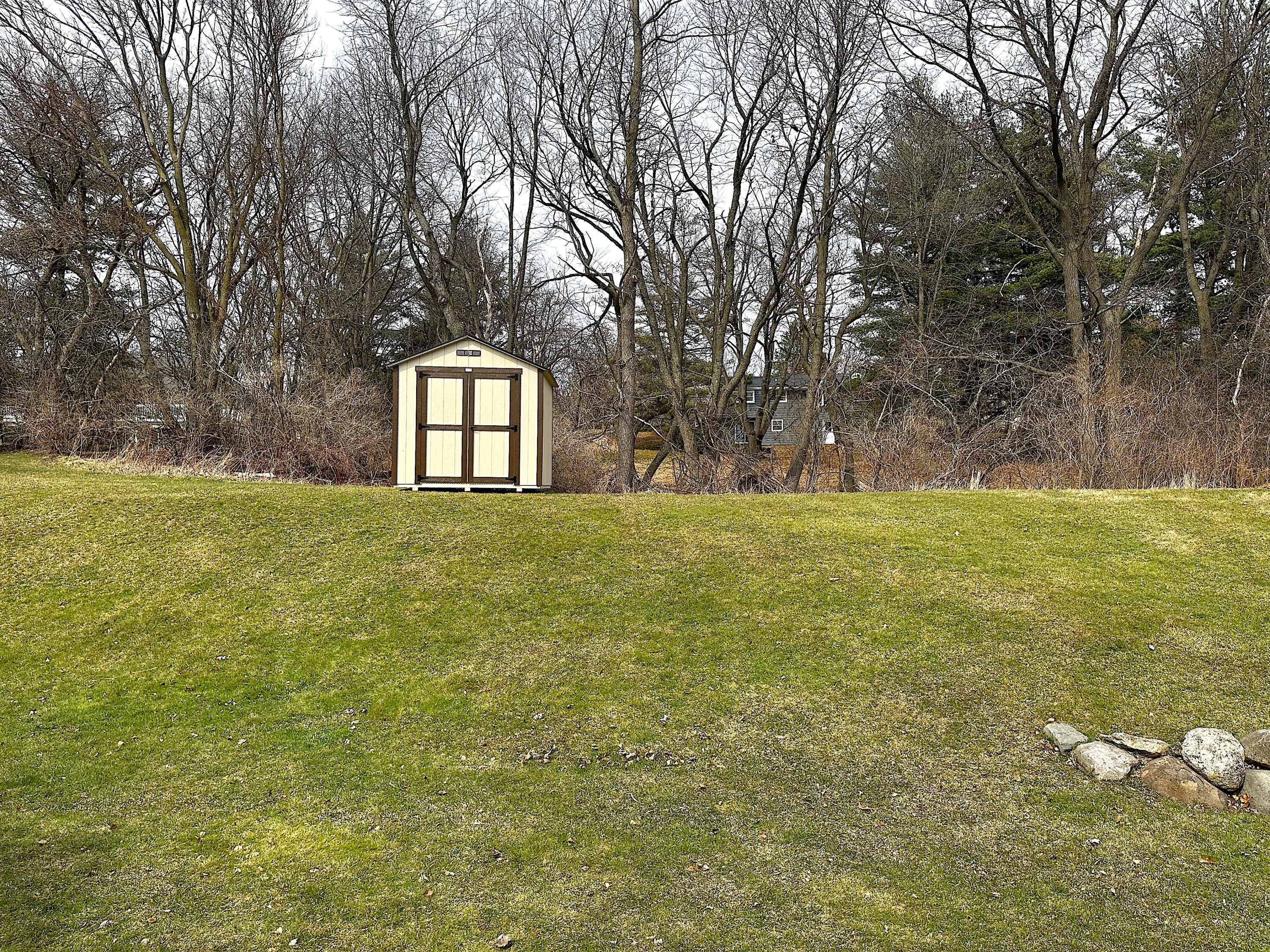 482 Fox Lane Walworth, WI 53184 - Photo 20 of 20 The rear yard is lined by trees and has a convenient newer shed for extra storage