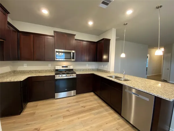 a kitchen with granite countertop stainless steel appliances and wooden cabinets
