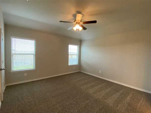 an empty room with a window and a fan