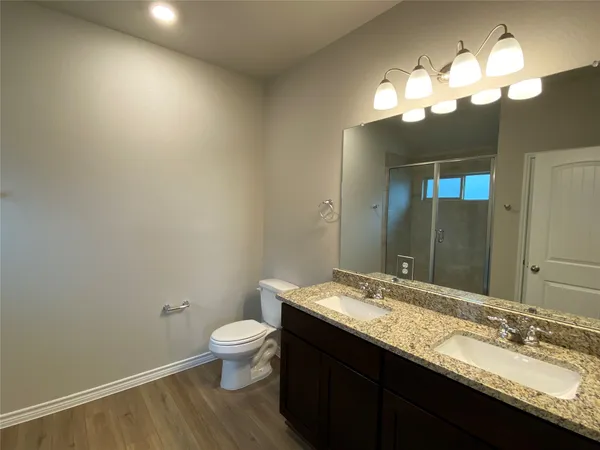 a bathroom with a granite countertop sink a toilet and a large mirror