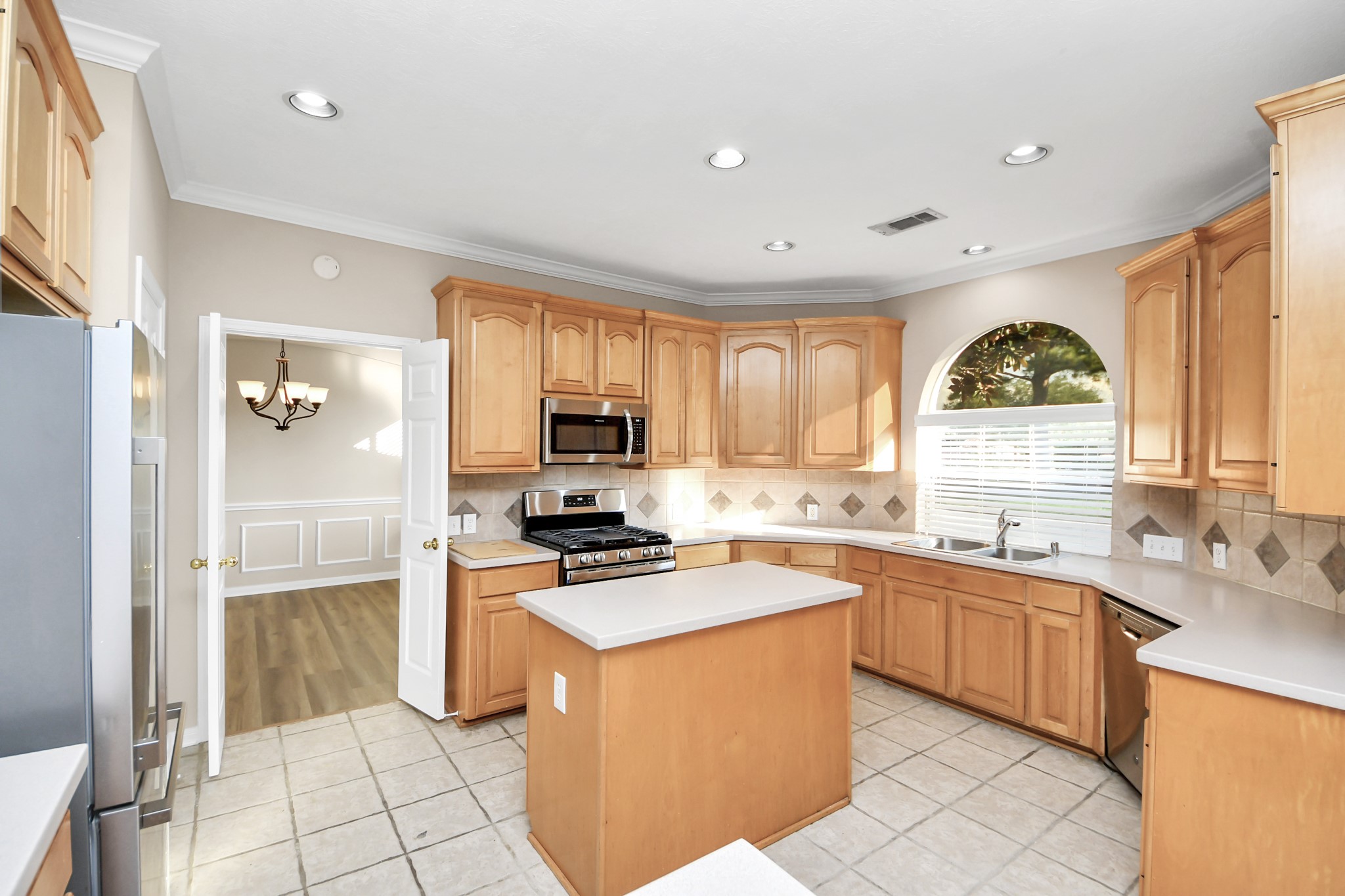 11918 Helene Court Pinehurst, TX 77362 - Photo 14 of 50 a kitchen with stainless steel appliances a stove sink microwave and cabinets