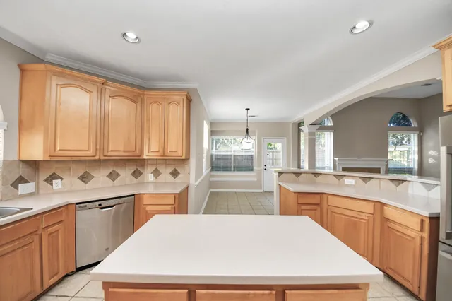 a kitchen with stainless steel appliances granite countertop a refrigerator a sink dishwasher a stove top oven a refrigerator with island and cabinets