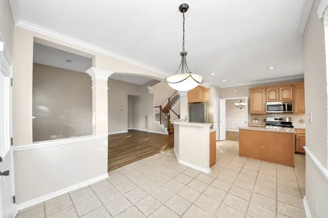 a kitchen with white cabinets and window