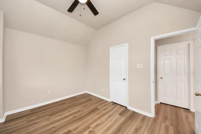 a view of a room with wooden floor and a ceiling fan