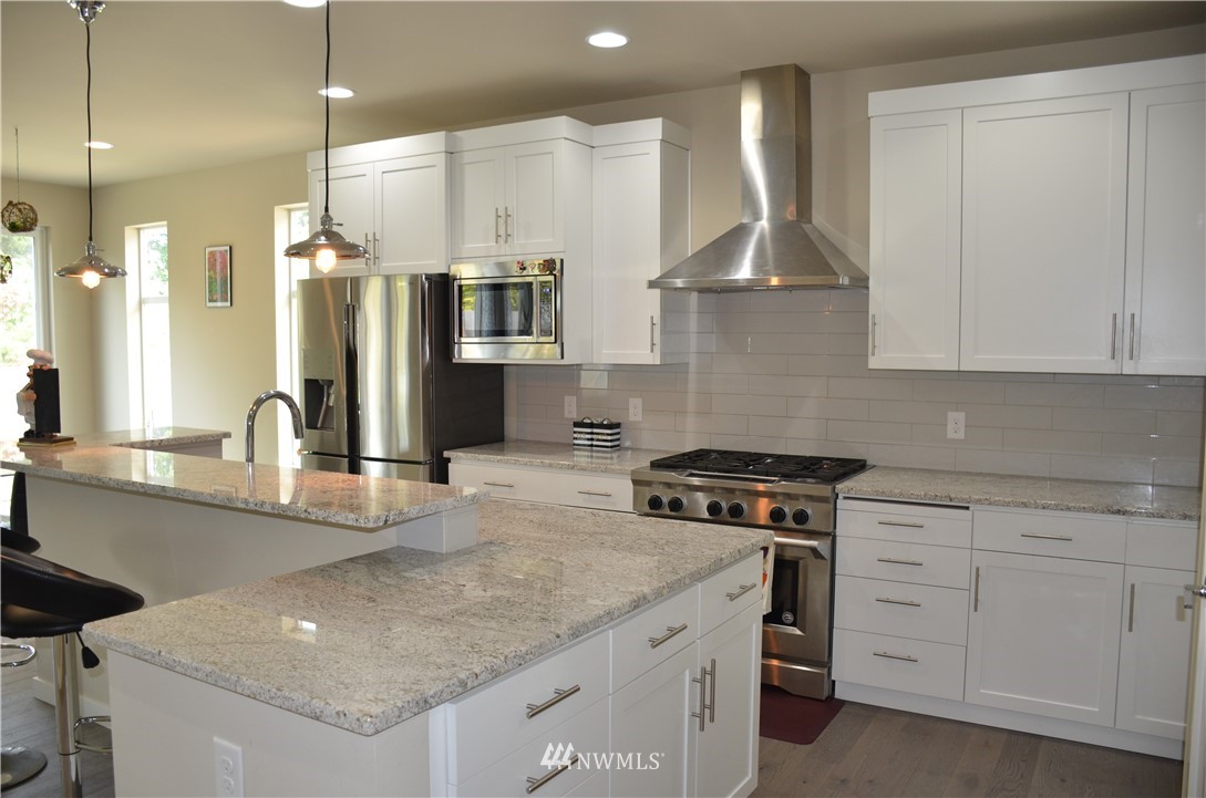 29 175th Place Southeast Bothell, WA 98012 - Photo 3 of 19 a kitchen with stainless steel appliances granite countertop a sink a stove and a refrigerator
