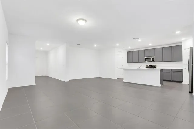 a view of kitchen with kitchen island a sink stainless steel appliances and cabinets