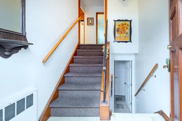 a view of staircase with lots of frames on wall and a painting