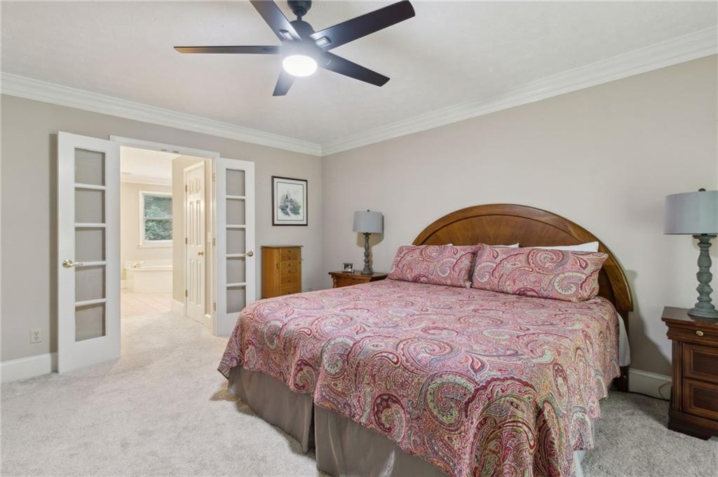 83 Russell Road Lawrenceville, GA 30043 - Photo 26 of 67 a bedroom with a bed and a chandelier