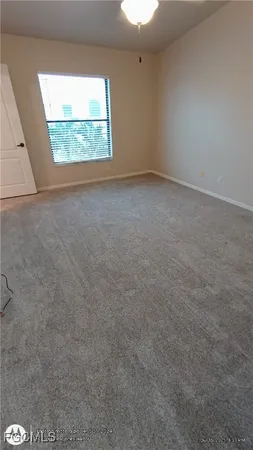 en empty room with windows and ceiling fan