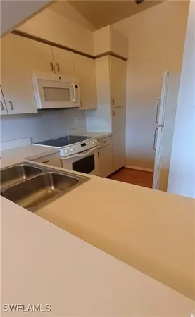 a kitchen with stainless steel appliances granite countertop a sink a stove and refrigerator