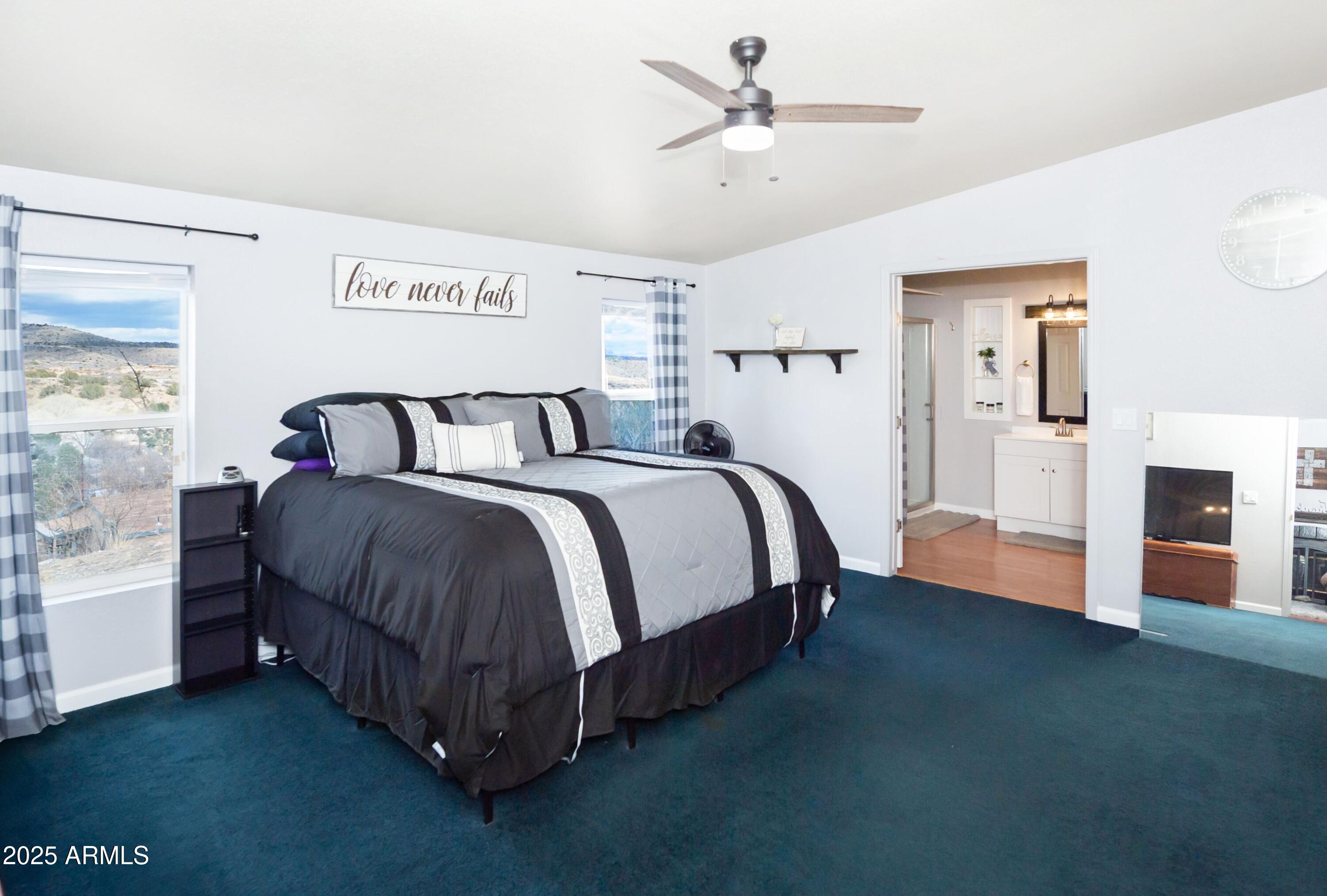 12320 Jacobs Road Mayer, AZ 86333 - Photo 15 of 37 a spacious bedroom with a bed and a chandelier