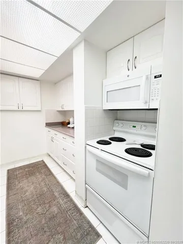 a kitchen with white cabinets and white appliances
