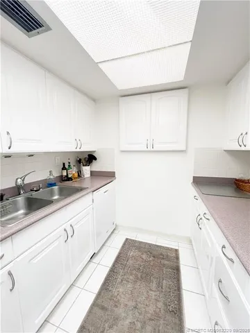 a kitchen with granite countertop white cabinets and white appliances