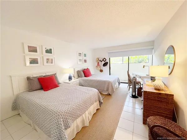 a bedroom with two beds and a large window