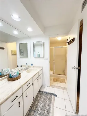 a bathroom with a double vanity sink mirror and shower