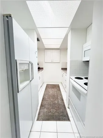 a kitchen with white cabinets and white appliances