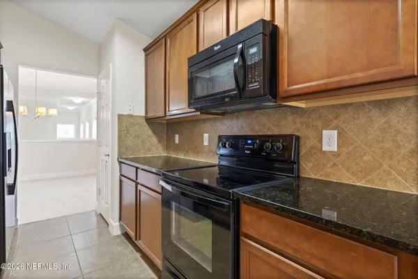 a kitchen with stainless steel appliances granite countertop a sink stove and microwave