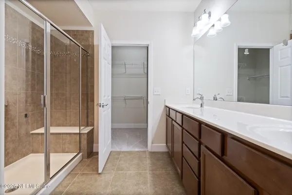 a bathroom with a double vanity sink a mirror and a shower
