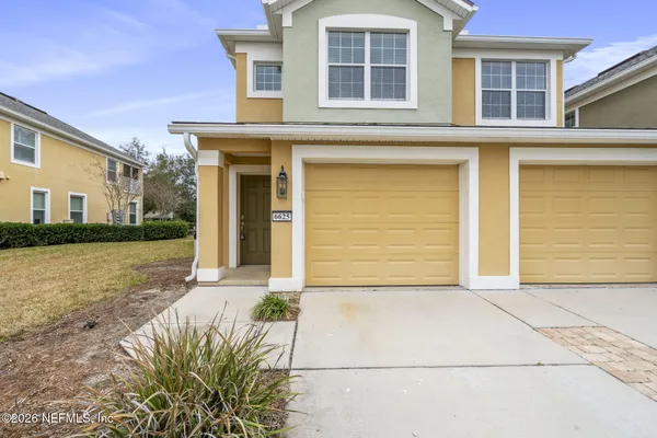 a front view of a house with a yard and garage