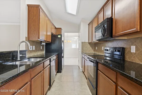 a kitchen with stainless steel appliances granite countertop a stove microwave and sink