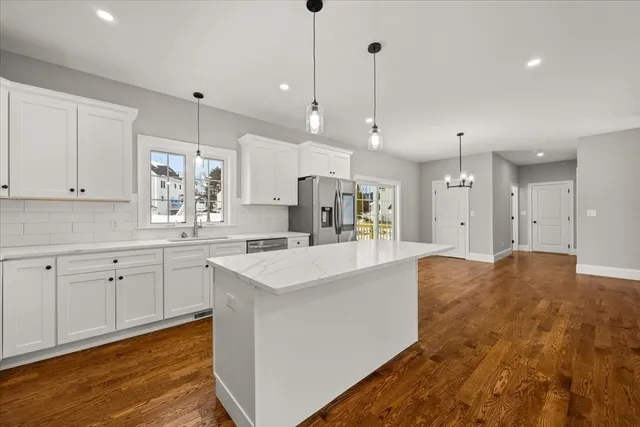 a large kitchen with kitchen island a sink stainless steel appliances and cabinets
