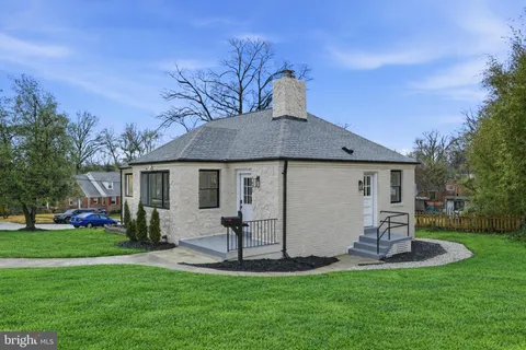 a front view of house with a garden and trees