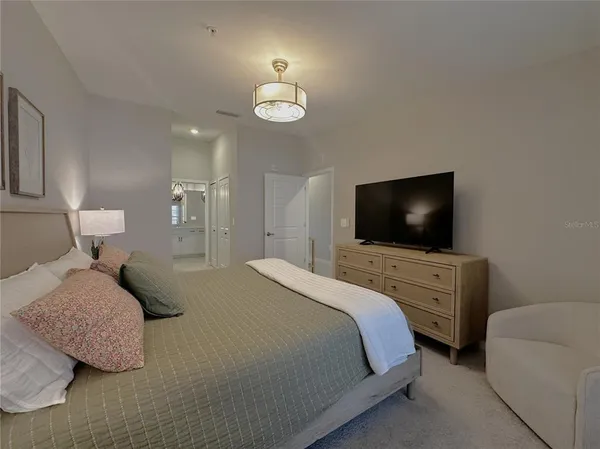 a bedroom with a bed and a flat screen tv