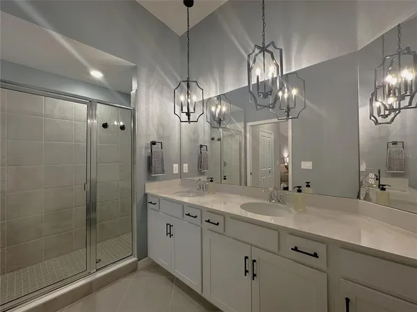 a bathroom with double vanity and a mirror