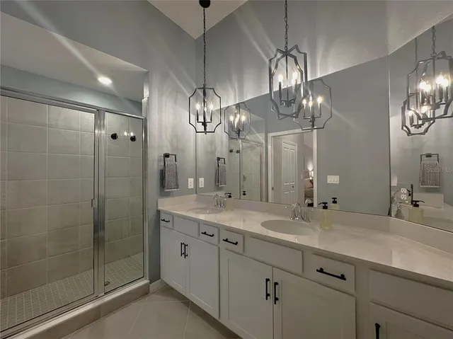 a bathroom with double vanity and a mirror