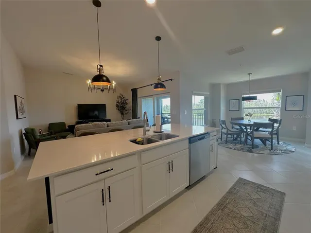 a view of living room with granite countertop furniture a sink a flat screen tv and a view of kitchen