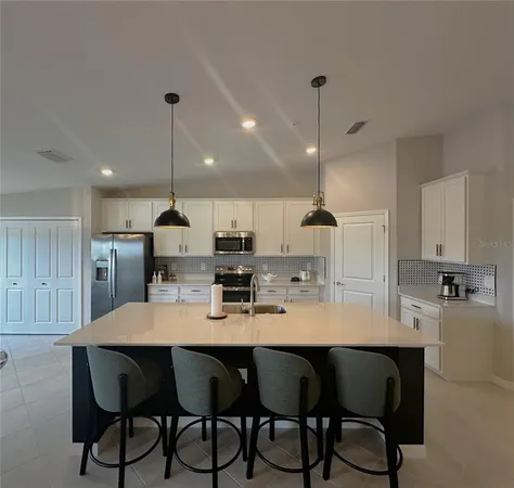 a large kitchen with a dining table chairs wooden floor and appliances