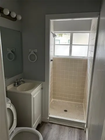 a bathroom with a granite countertop sink toilet and shower
