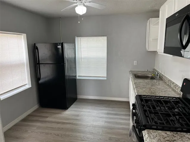 a kitchen with stainless steel appliances granite countertop a refrigerator and a stove