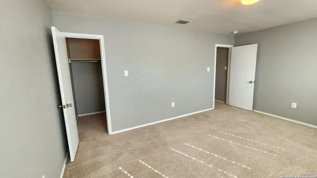 an empty room with closet and a bathroom
