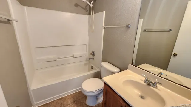 a view of an empty room with a chandelier fan