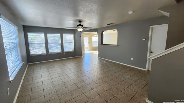 an empty room with windows and chandelier