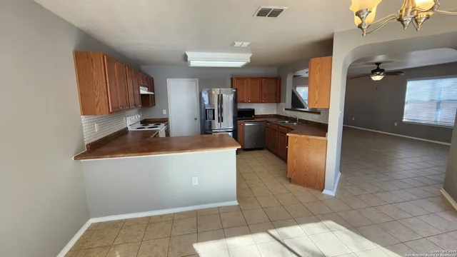 a kitchen with stainless steel appliances granite countertop a stove a sink and a refrigerator