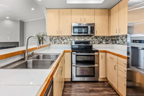 a kitchen with stainless steel appliances granite countertop a stove a sink and a microwave