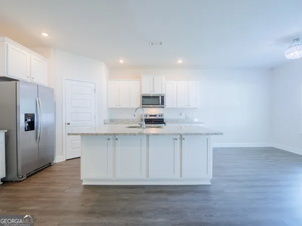 a kitchen with stainless steel appliances a refrigerator sink and white cabinets
