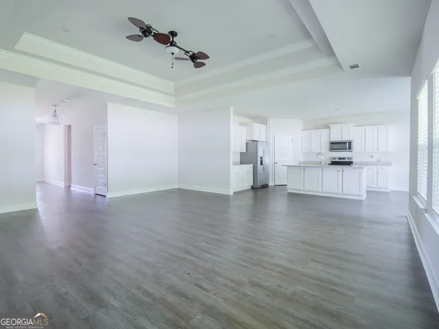 a kitchen with stainless steel appliances granite countertop white cabinets a sink a stove a refrigerator and white cabinets