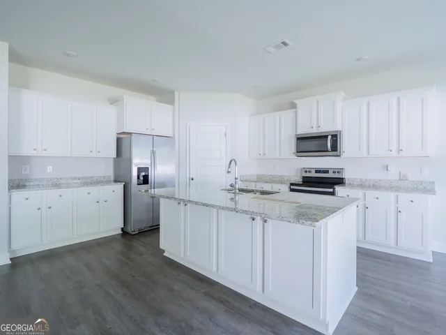 a kitchen with a sink a stove top oven and white kitchen