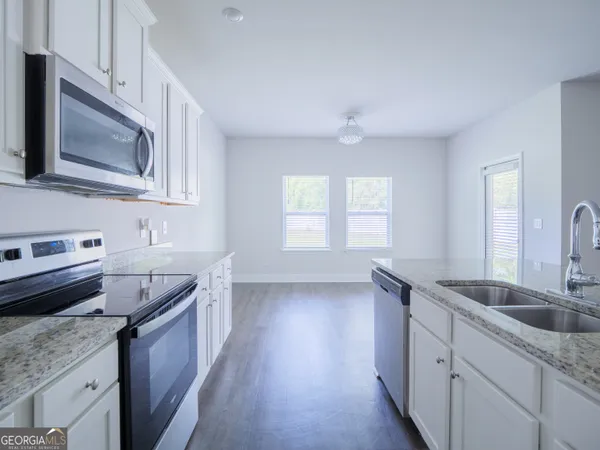 a kitchen with kitchen island white cabinets and stainless steel appliances